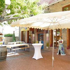 Terrasse vor großem Raum mit einem Schirm